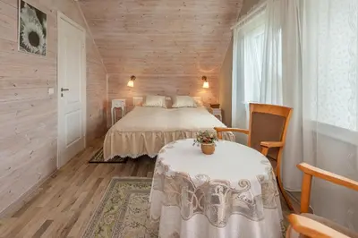 a bedroom with a bed and a table in a room at Vila Terra Resort in Girsteitiškis