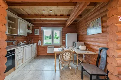 a kitchen with a table and chairs in a cabin at Vila Terra Resort in Girsteitiškis