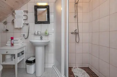 a white bathroom with a sink and a shower at Vila Terra Resort in Girsteitiškis