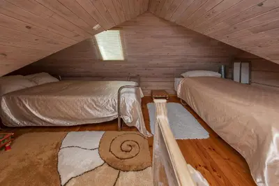 a attic room with two beds and a rug at Vila Terra Resort in Girsteitiškis