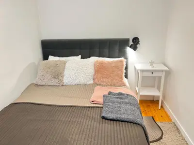 a bed with a black headboard in a room at Cozy appartment in the Heart of Old Town with free parking in Vilnius