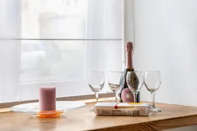 a table with wine glasses and a bottle of wine at Cozy appartment in the Heart of Old Town with free parking in Vilnius