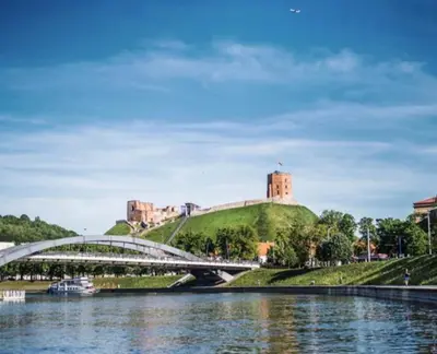 a bridge over a river in front of a castle at Cozy appartment in the Heart of Old Town with free parking in Vilnius
