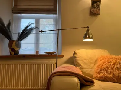 a lamp in a room with a chair and a window at Cozy appartment in the Heart of Old Town with free parking in Vilnius