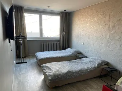 two twin beds in a room with a window at Central place with lake view in Šiauliai