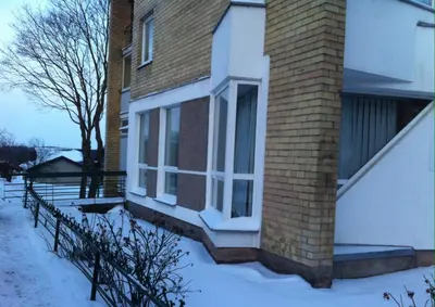 a house with a brick chimney with snow on the ground at Central place with lake view in Šiauliai