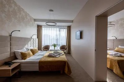 a hotel room with two beds and a window at Grand SPA Lietuva Hotel Lietuva in Druskininkai