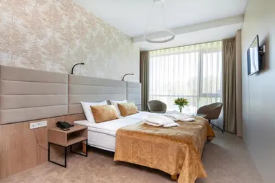 a hotel room with a bed and a table at Grand SPA Lietuva Hotel Lietuva in Druskininkai