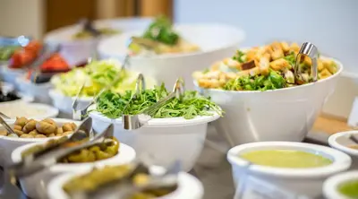 a table topped with bowls of food and plates of food at MEDEA Apartments by UPA in Druskininkai