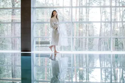 a woman is standing in front of a window at MEDEA Apartments by UPA in Druskininkai