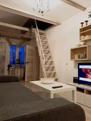 a living room with a couch and a tv and stairs at Dp Art 14 OLD TOWN Self check in in Kaunas