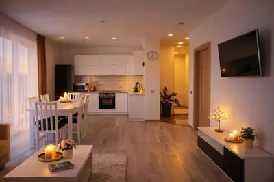 a living room and kitchen with a table and chairs at Ąžuolo apartamentai in Birštonas