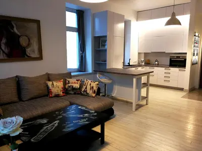 a living room with a couch and a kitchen at Vilnius apartment with stained glass in Vilnius
