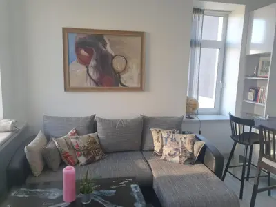 a living room with a couch and a painting on the wall at Vilnius apartment with stained glass in Vilnius