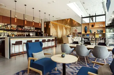 a restaurant with blue chairs and a bar at Courtyard by Marriott Vilnius City Center in Vilnius