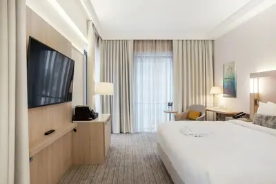 a hotel room with a bed and a flat screen tv at Courtyard by Marriott Vilnius City Center in Vilnius
