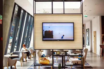 a lobby with a tv on the wall at Courtyard by Marriott Vilnius City Center in Vilnius
