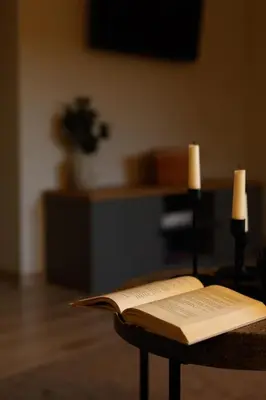 an open book sitting on a table with two candles at Sodeliškių dvaro sodyba in Sodeliškiai