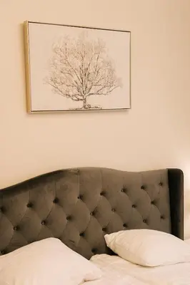 a picture of a tree hanging above a bed at Sodeliškių dvaro sodyba in Sodeliškiai
