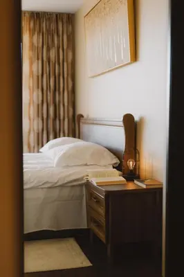 a bedroom with a bed and a night stand with a desk at Sodeliškių dvaro sodyba in Sodeliškiai