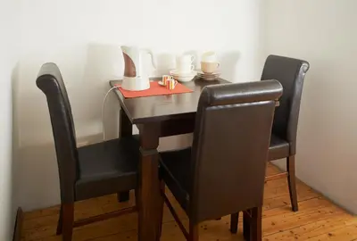 a wooden table with two chairs and a red napkin at Regina House- sv. Mikalojaus 13 in Vilnius