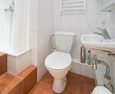 a white bathroom with a toilet and a sink at Regina House- sv. Mikalojaus 13 in Vilnius