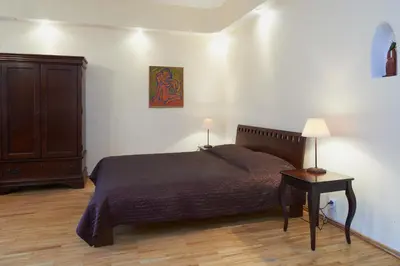 a bedroom with a bed and a cabinet and a table at Regina House- sv. Mikalojaus 13 in Vilnius