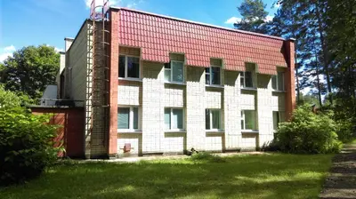 a large brick building with a red roof at Visagino parkas in Visaginas