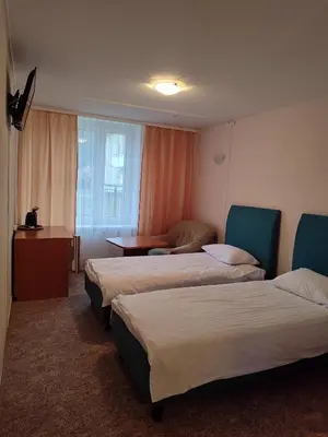 a hotel room with two beds and a table at Visagino parkas in Visaginas