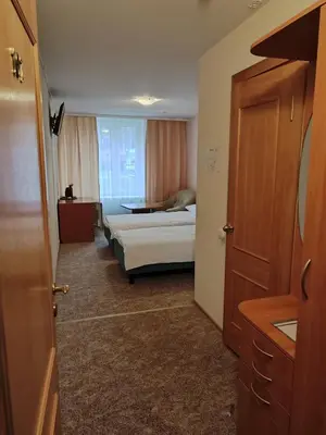 a hotel room with a bed and a door at Visagino parkas in Visaginas