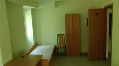 a room with a bed and a cabinet and a chair at Visagino parkas in Visaginas