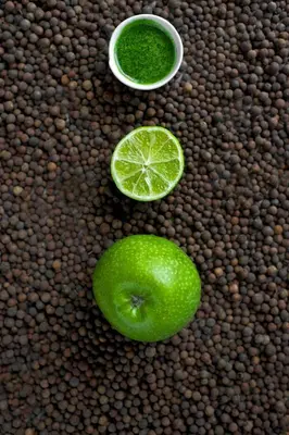 a green apple and a lime and a bowl of green liquid at Green Vilnius Hotel in Vilnius