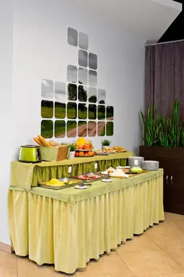 a table with a yellow table cloth with food on it at Green Vilnius Hotel in Vilnius