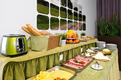 a buffet with a table with food on it at Green Vilnius Hotel in Vilnius