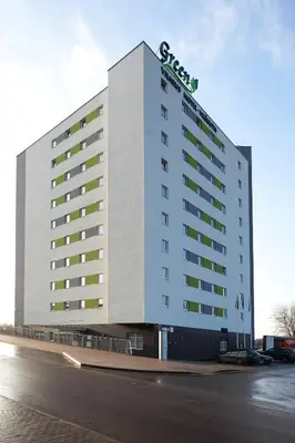 a large building with a sign on top of it at Green Vilnius Hotel in Vilnius