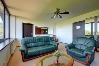 a living room with a couch and two chairs at Aerohotel in Vilnius
