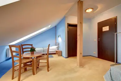 a room with a table and chairs and a bedroom at Aerohotel in Vilnius