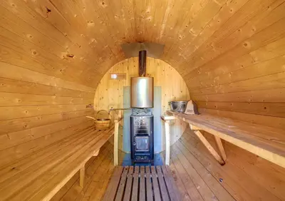 a wooden sauna with a stove in the middle at Aerohotel in Vilnius
