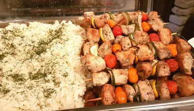 a tray of food with rice and meat and vegetables at Aerohotel in Vilnius