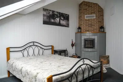 a bedroom with a bed and a brick fireplace at Apartamentai Birštono centre su židiniu in Birštonas