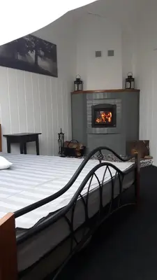 a bedroom with a bed and a fireplace at Apartamentai Birštono centre su židiniu in Birštonas