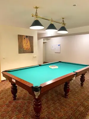 a pool table in a living room with two lights at Hotel-Restaurant Smilga in Kėdainiai