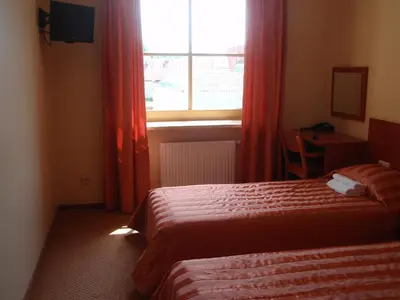 a hotel room with two beds and a window at Hotel-Restaurant Smilga in Kėdainiai