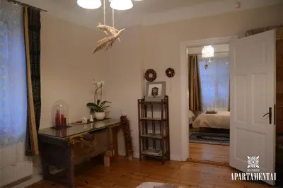 a living room with a table and a bedroom at Senamiesčio APARTAMENTAI in Panevėžys