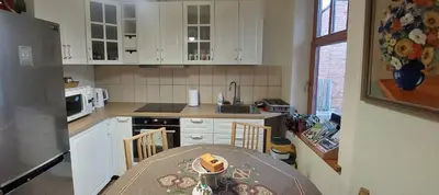a kitchen with a table and a kitchen with white cabinets at Senamiesčio APARTAMENTAI in Panevėžys