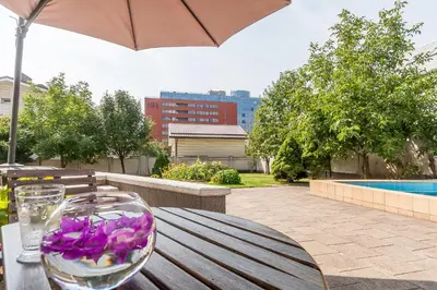 a wooden table with a wine glass and purple flowers on it at House Marija in Vilnius