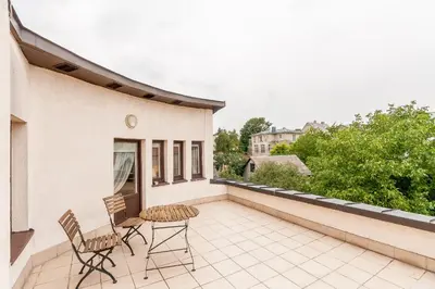 a patio with two chairs and a table on a balcony at House Marija in Vilnius