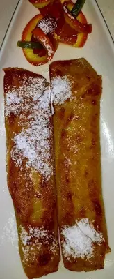 two slices of food on a white plate with fruit at Hotel Centras in Šakiai