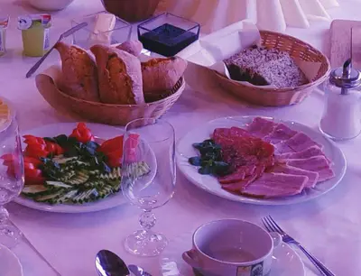 a table with plates of food and bowls of food at Hotel Centras in Šakiai