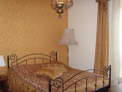a bedroom with a bed and a lamp and curtains at Hotel Centras in Šakiai